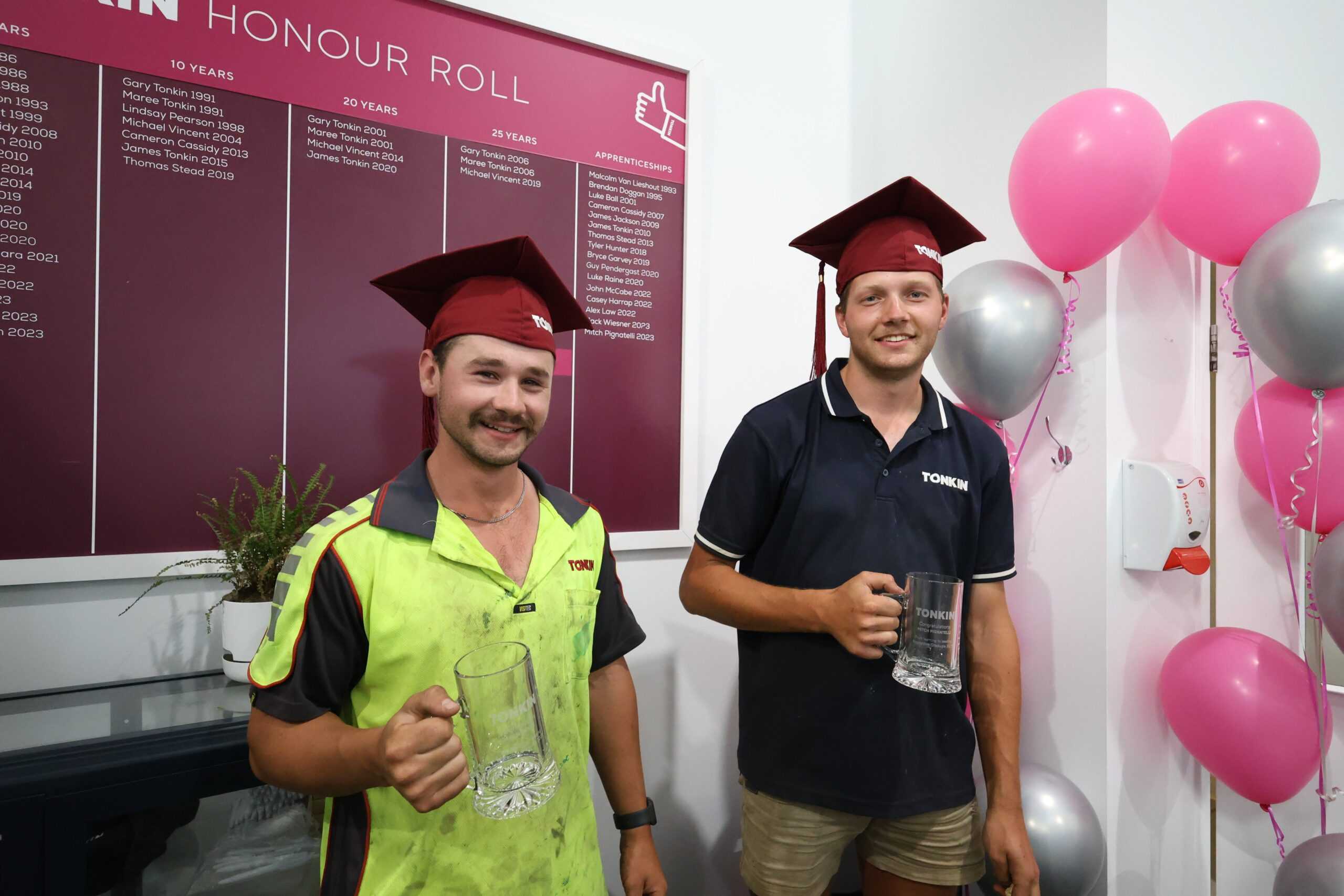 Mitch and Jack from Tonkin Group celebrating in front of the Tonkin Roll of Honour.