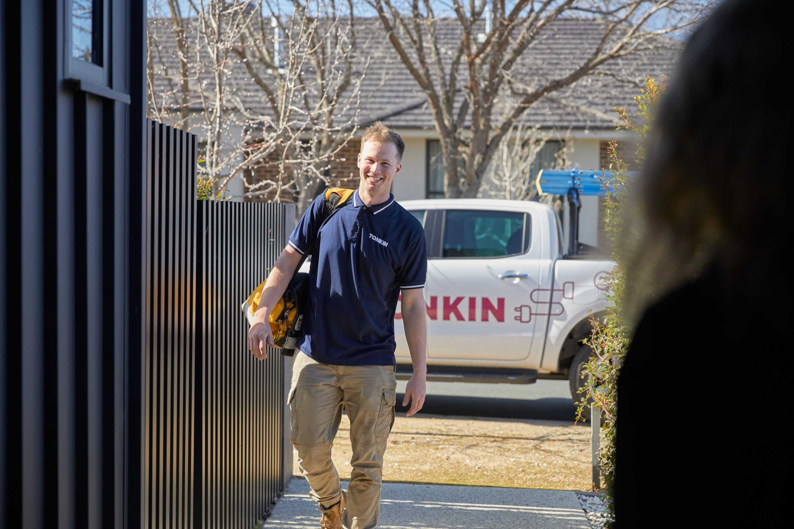 A Tonkin Group employee arriving at a customers house, with a Tonkin car in the background.