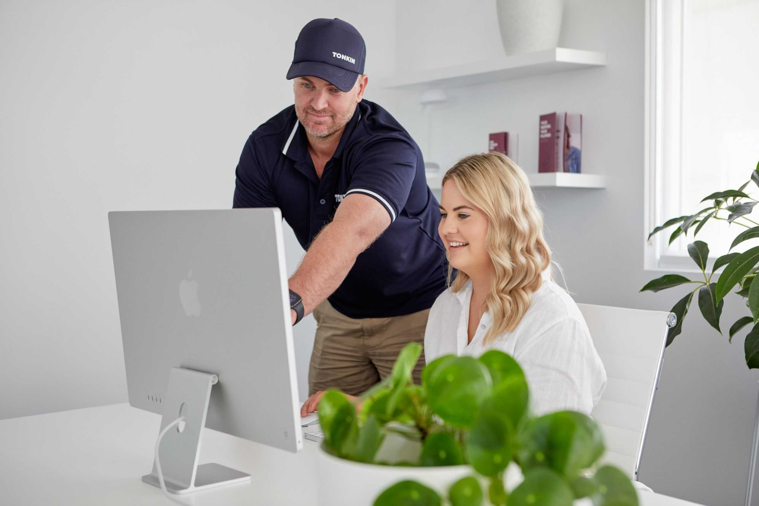 Two Tonkin Group employees looking at a computer.