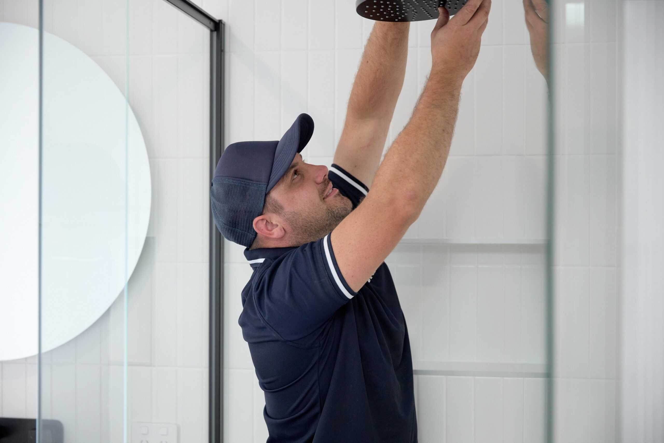 A Tonkin Group employee changing a shower head.
